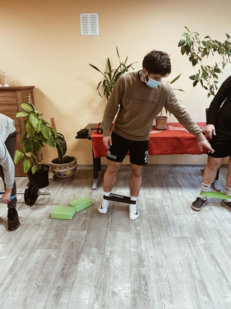 vīrietis stāv kājās, ap kājām sporta agumija