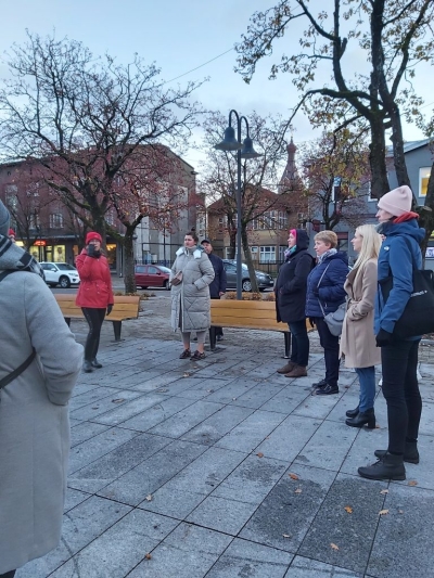 cilvēk stāv ārā, laukumā